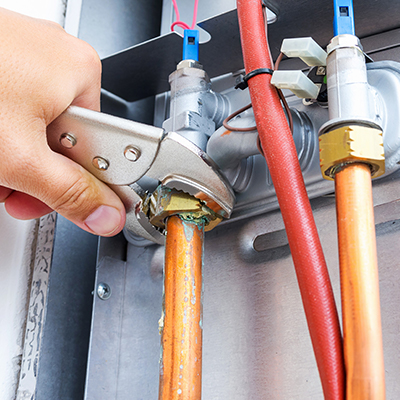A technician adjusting a bolt with his wrench while providing commercial HVAC services in London Ontario