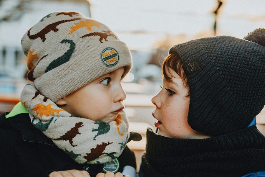 Two kids looking at each other in winter wondering if it's time to call for an emergency furnace repair